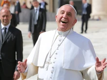 Pope Francis laughs outside of St. Peter’s Basilica during the general audience on April 1, 2015.