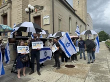 Participants at a May 22, 2025, afternoon vigil to honor the two lives lost in an attack outside the Capital Jewish Museum in Washington, D.C., the night before hold signs reading “Christians and Jews united against hate.”
